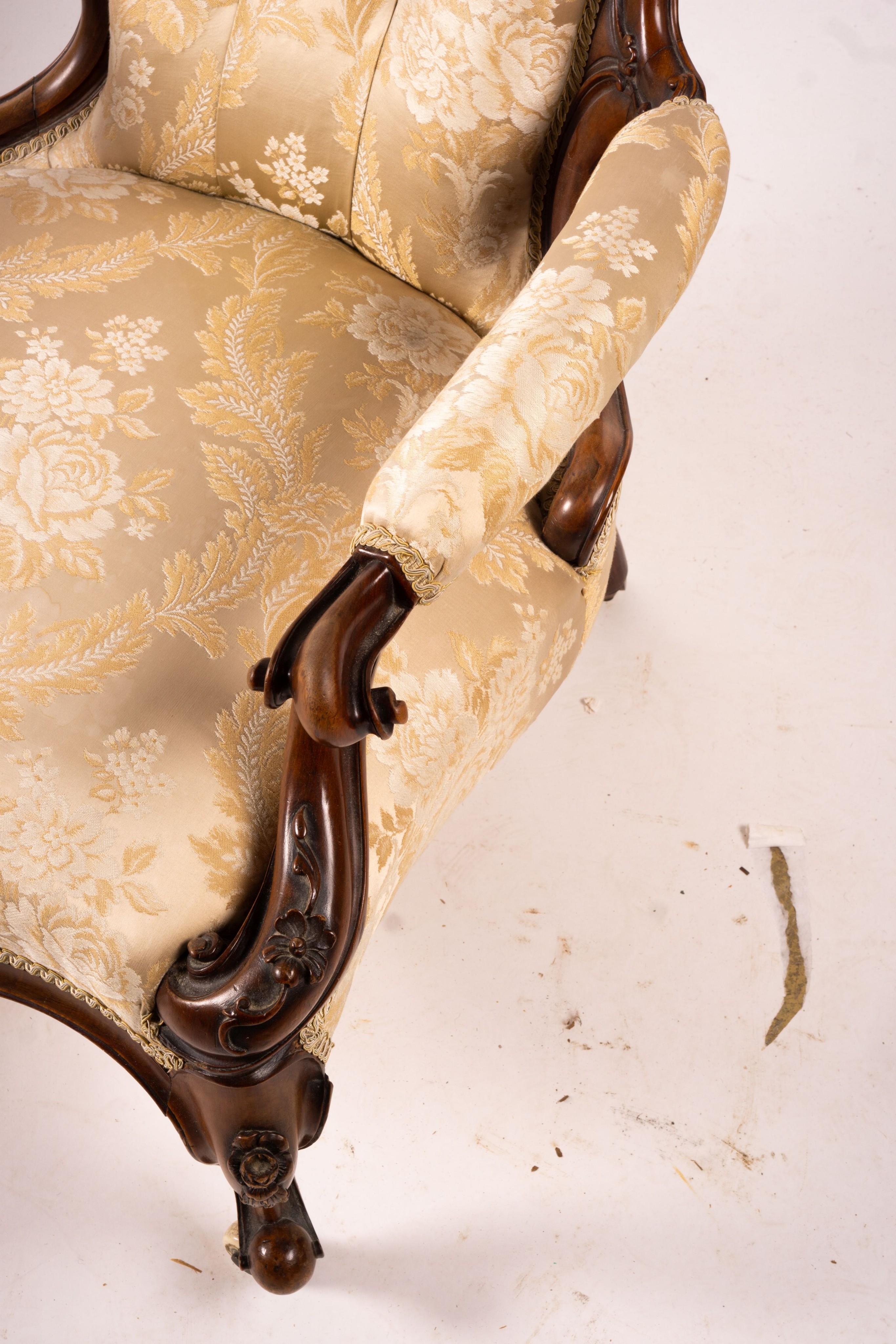 A late Victorian carved walnut three piece salon suite, comprising chaise longue, open armchair and nursing chair